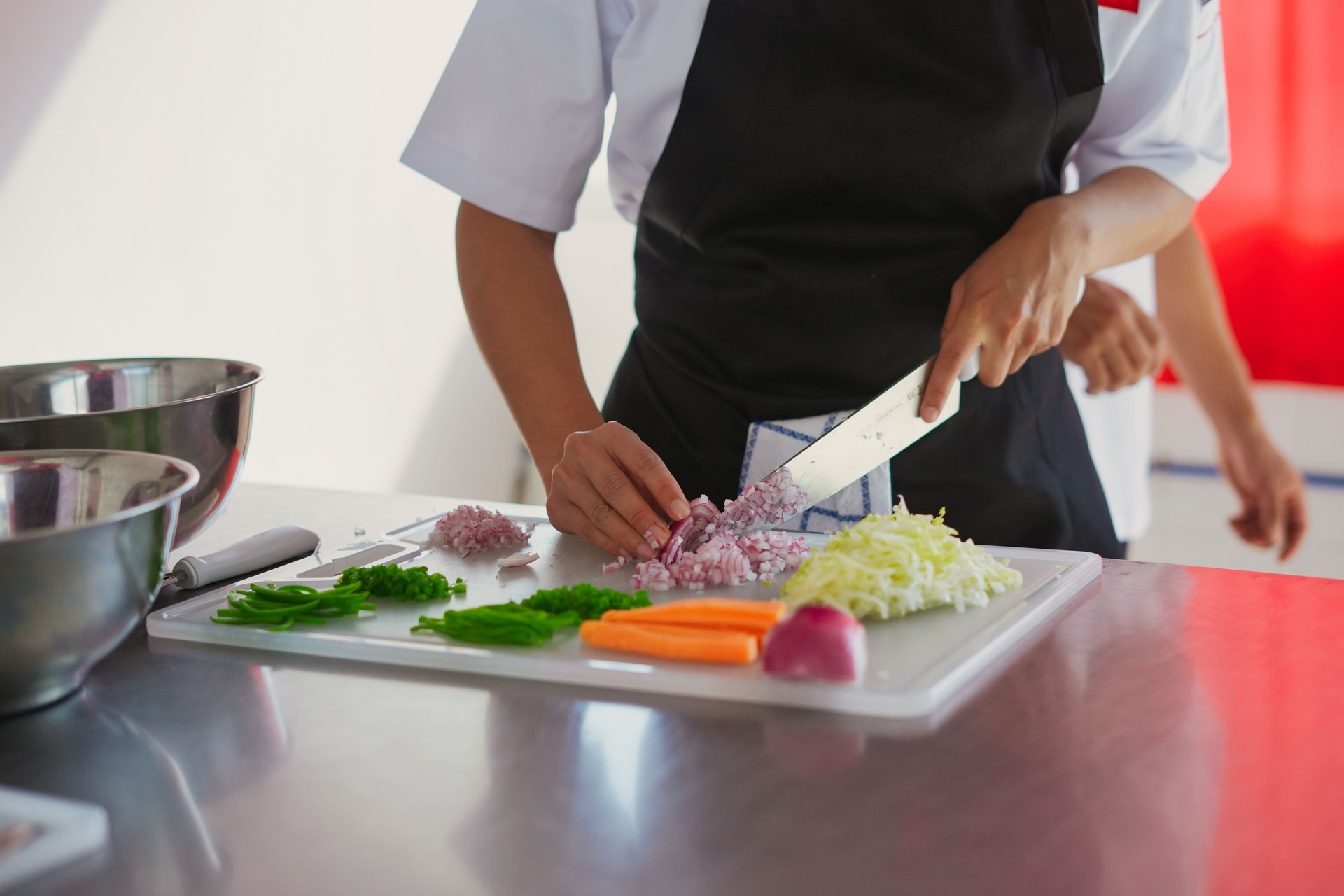 Chef chopping fresh vegetables on cutting board in kitchen Chef chopping fresh vegetables on cutting board in kitchen